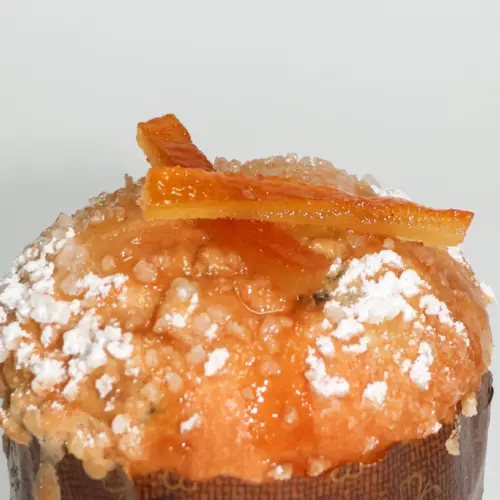 Zoom sur le dessus de la briochette à l'orange avec du sucre glace sur le dessus