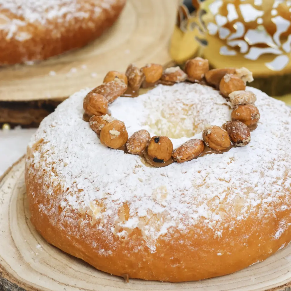 Brioche des Rois “Praliné noisette et amandes torréfiées” avec un rond d'amandes et du sucre glace sur le dessus