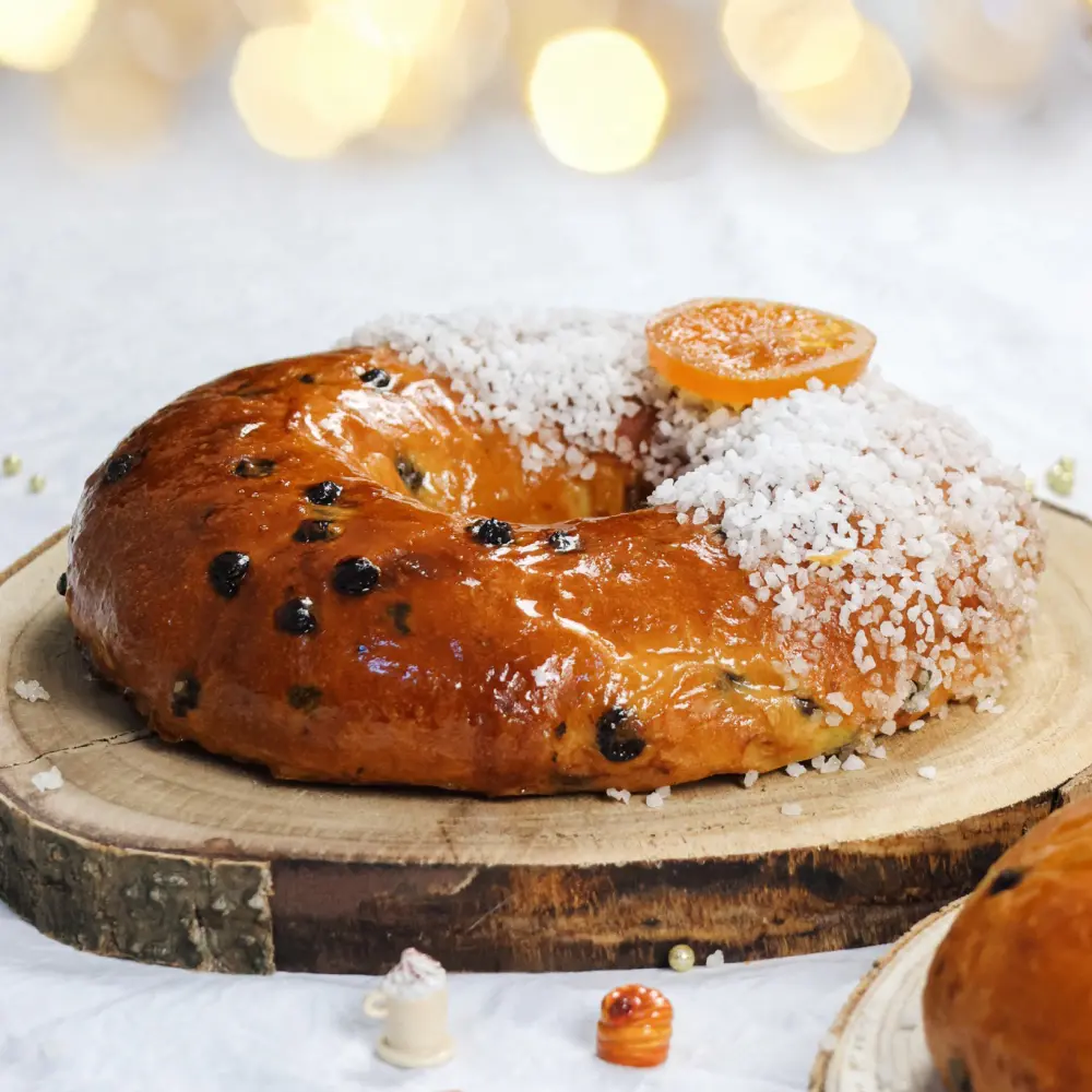 La brioche des rois "chocolat/orange" avec du sucre glace, des morceaux de chocolat et une tranche d'orange confite sur le dessus