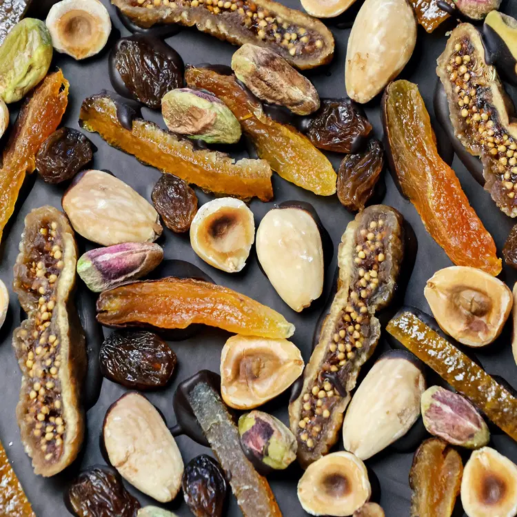 Zoom sur la garniture mendiant "noisettes, pistaches, amandes, figue sechée, abricot sec, ecorces d’orange"