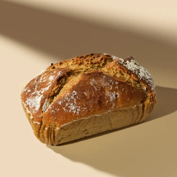 Pain de petit épeautre sur fond beige avec quelques ombres autour