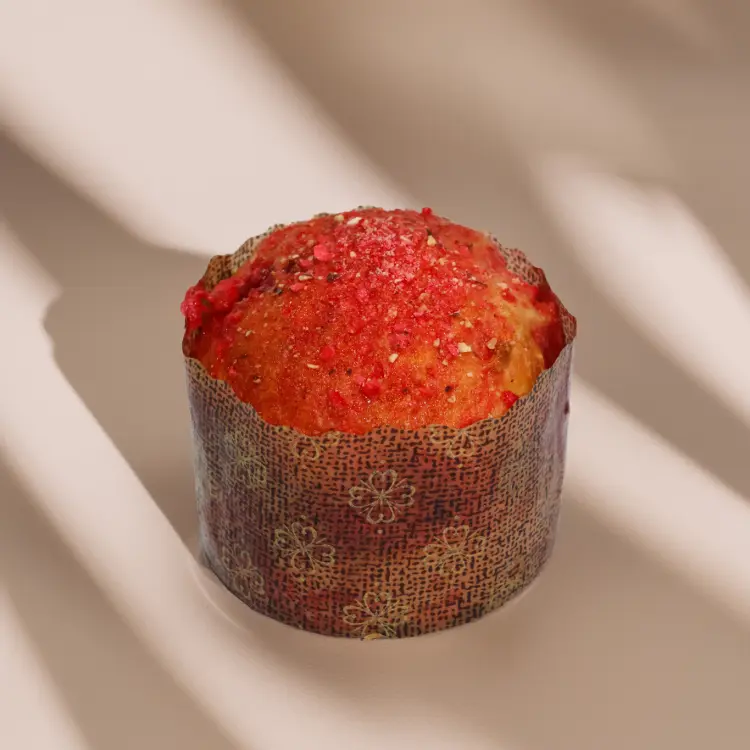 La brioche praline rose sur fond beige avec quelques ombres autour