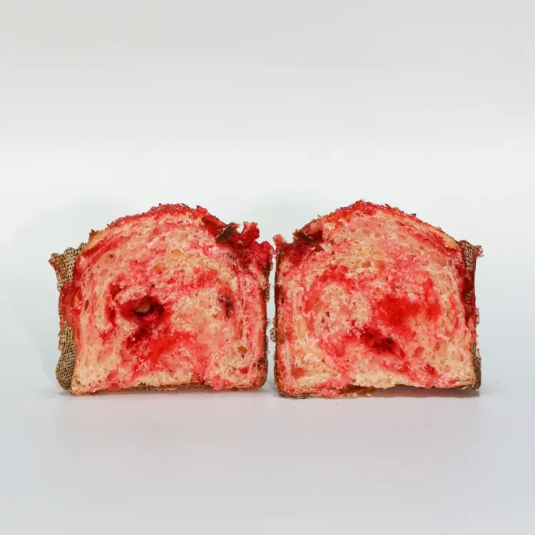 La brioche praline rose coupée en deux pour laisser voir les morceaux de pralines roses à l'intérieur