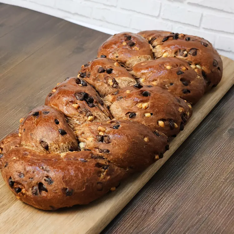 Brioche tout chocolat 900G posée sur une planche en bois dans un décor de cuisine