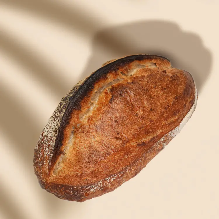 Pain de campagne pris de haut sur fond beige avec quelques ombres autour