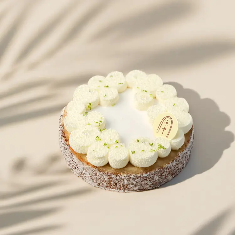 Tartelette coco citron vert sur fond beige avec quelques ombres autour