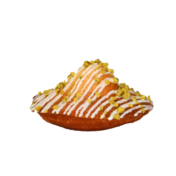 Madeleine fourrée à la pistache sur fond blanc