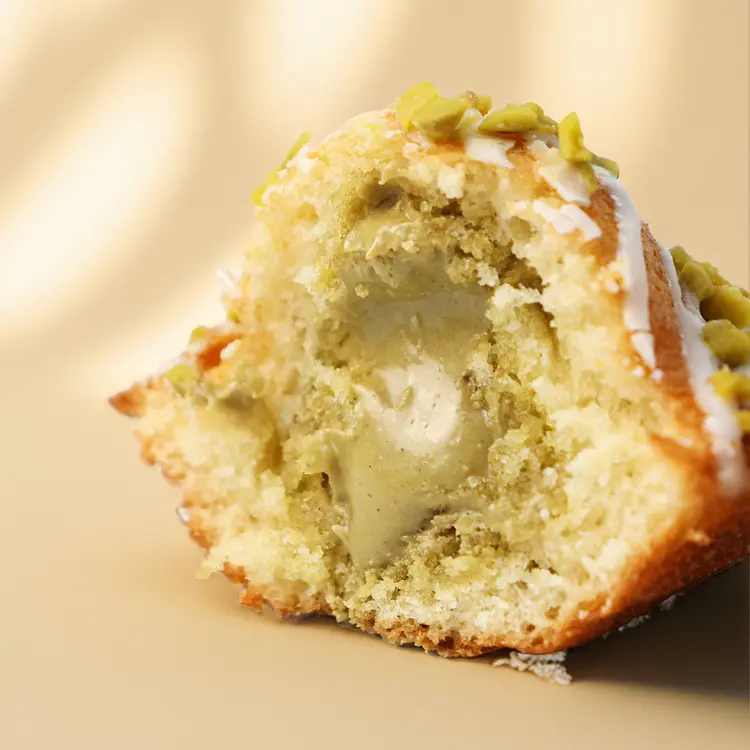 Zoom sur la pistache qui coule du coeur de la madeleine pistache