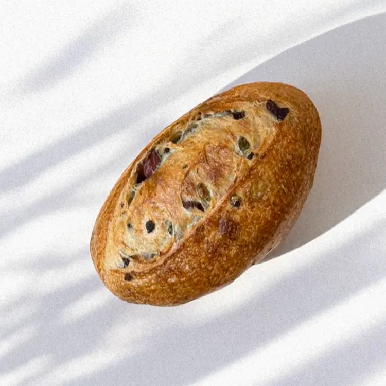 Zoom sur le pain aux olives pris de haut, sur fond blanc 