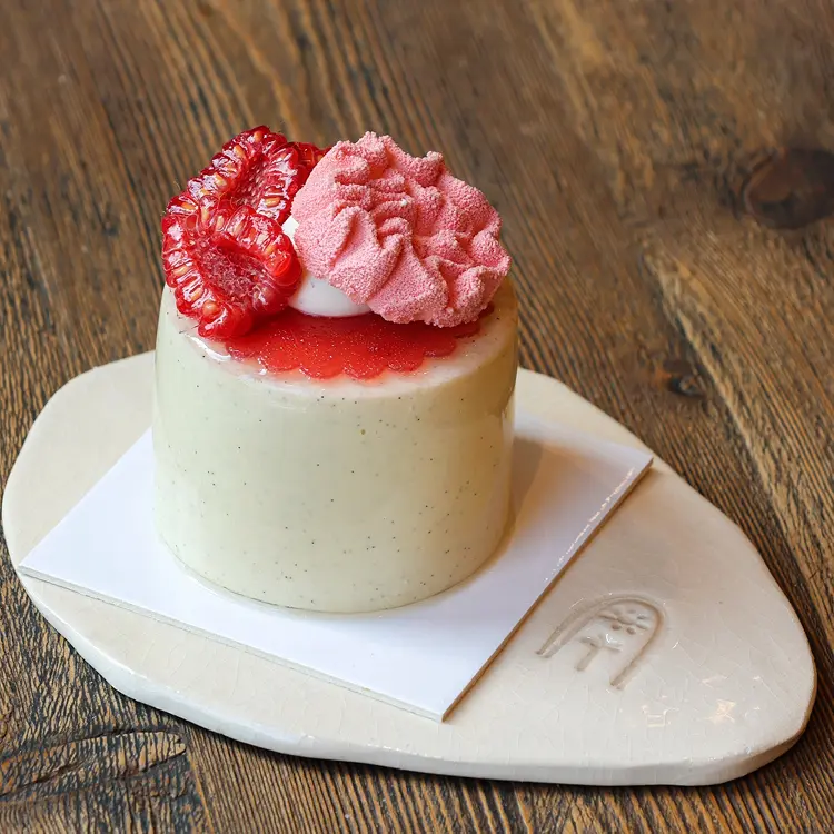 L'entremet des mamans à la framboise et coquelicot posé sur une assiette beige Les Petits Marchands
