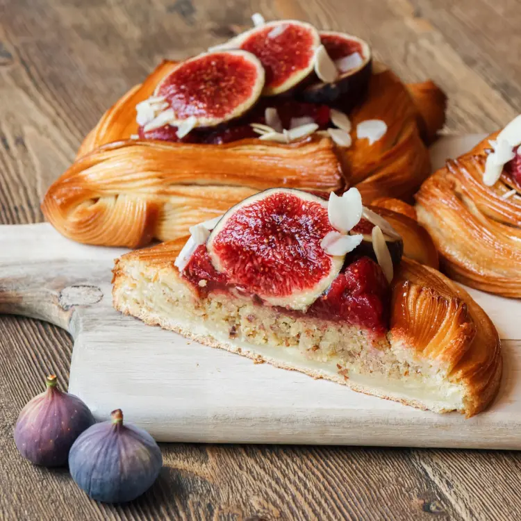 La viennoiserie panier de figue coupée en deux, avec la couche d'amande apparente au coeur