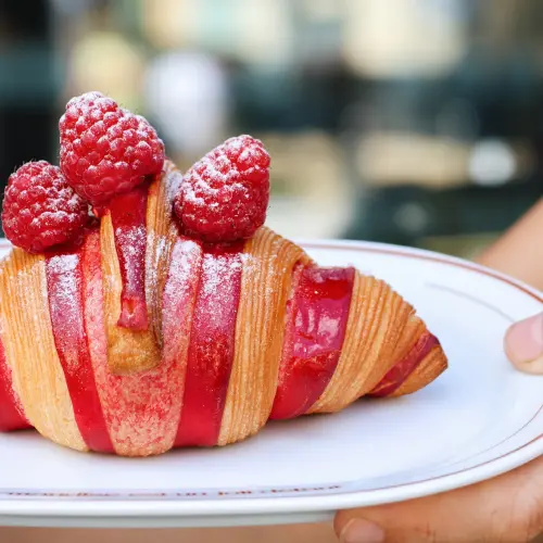  ⁠⁠Zoom sur le croissant bicolore à la framboise pour octobre rose, avec des framboises sur le dessus