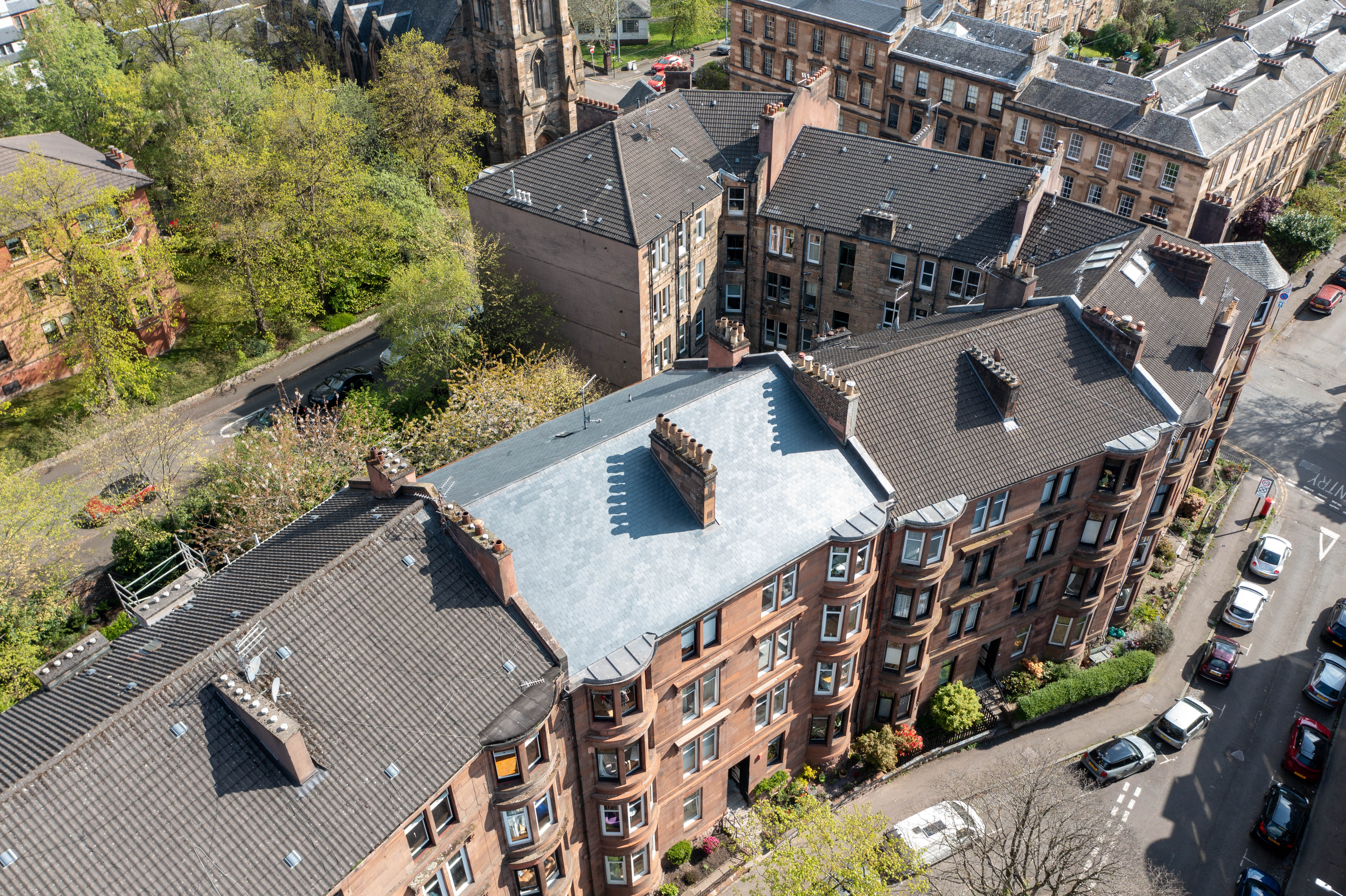 Repointed and cleaned red sandstone façade on a Victorian tenement on Caird Drive, Glasgow West End, following doff cleaning and stonework repairs