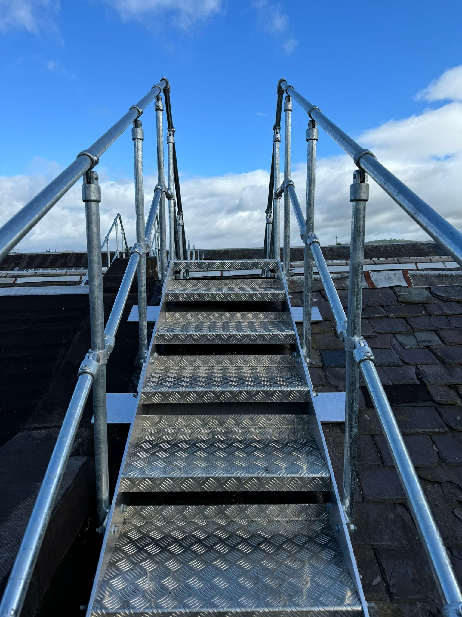 Close detail of chequer plate step unit with AKM guardrails installed on the sawtooth northlight roof at Stirling Enterprise Park, Stirling