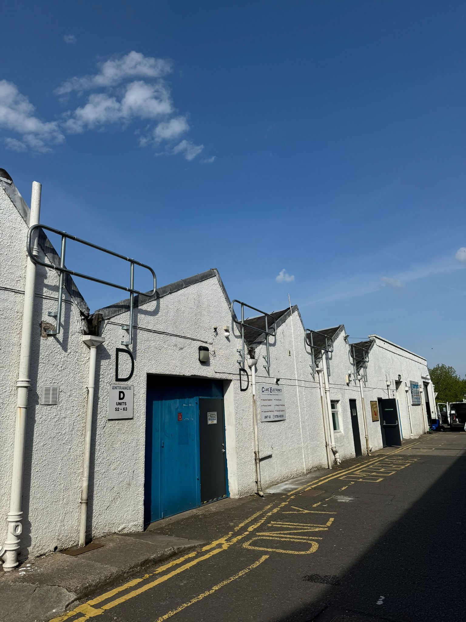 Street-level view of Stirling Enterprise Park showing the sawtooth roofline with newly installed roof access guardrails by Roofing Advisors