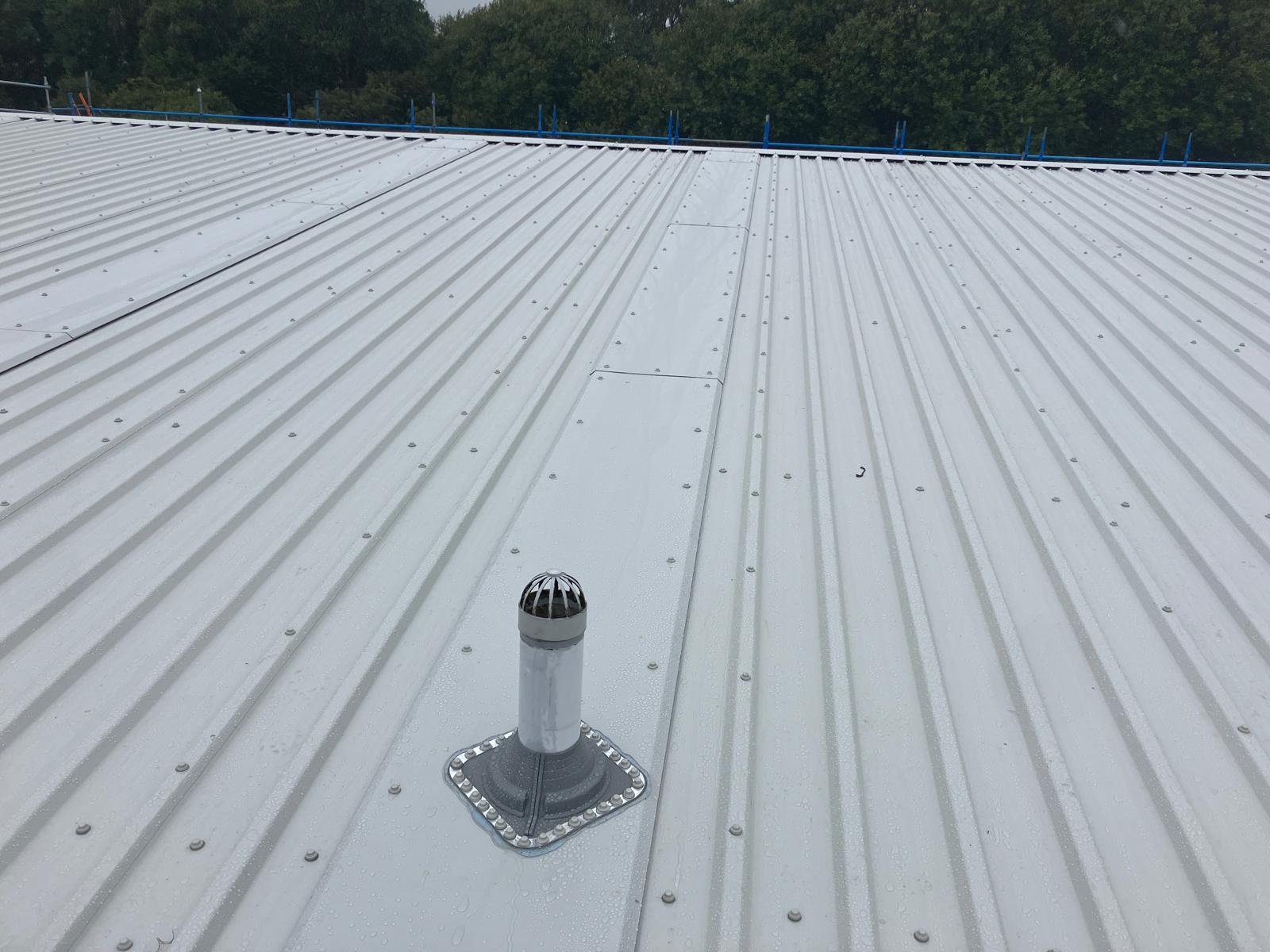 Completed roof overlay with dektite flashing details to pipe penetrations at an industrial building on Wallneuk Road, Paisley