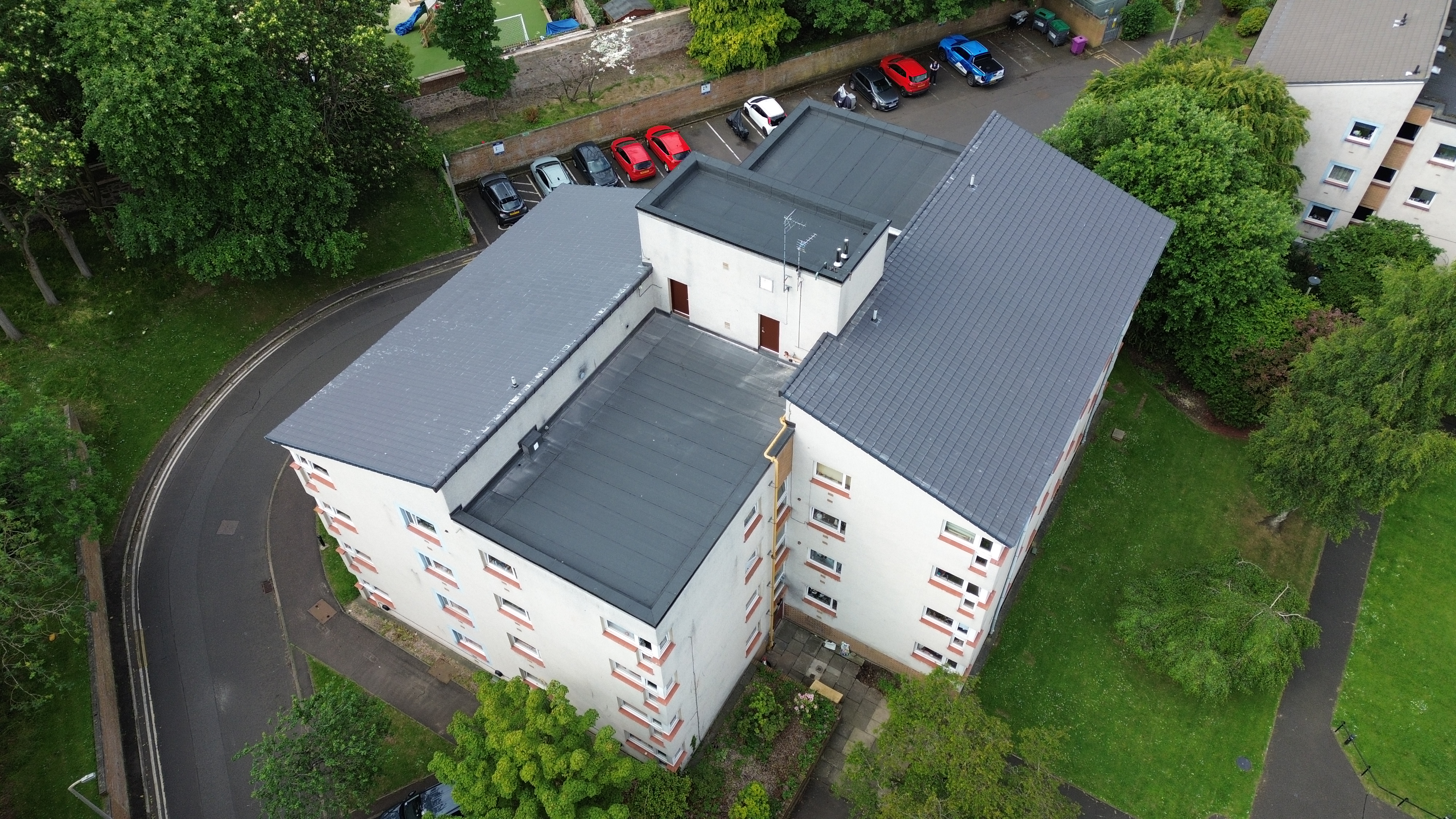 Aerial view of completed Marley pitched roof tiles and new Sika flat roofing system over the stairwell at a development in Edinburgh