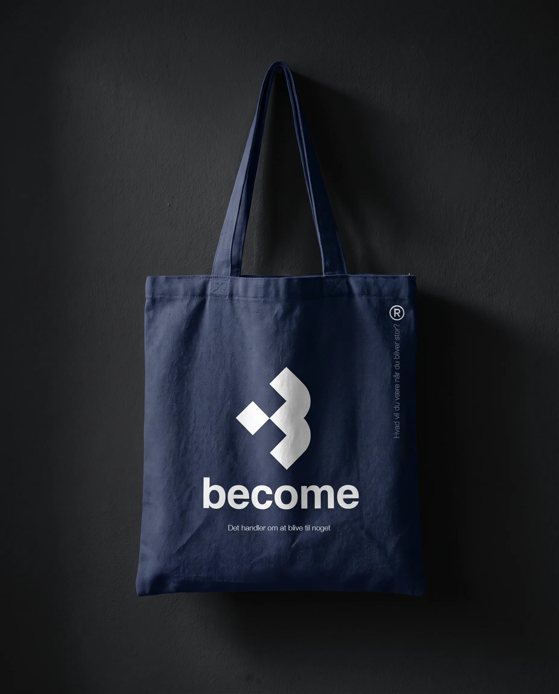 Become - morkeblaa totebag med bomaerke og tagline