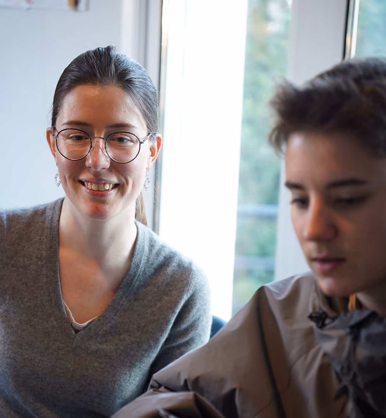 Un groupe de personnes assises autour d'une table en réunion, avec un dossier intitulé « Aide sociale à l'enfance » au premier plan.