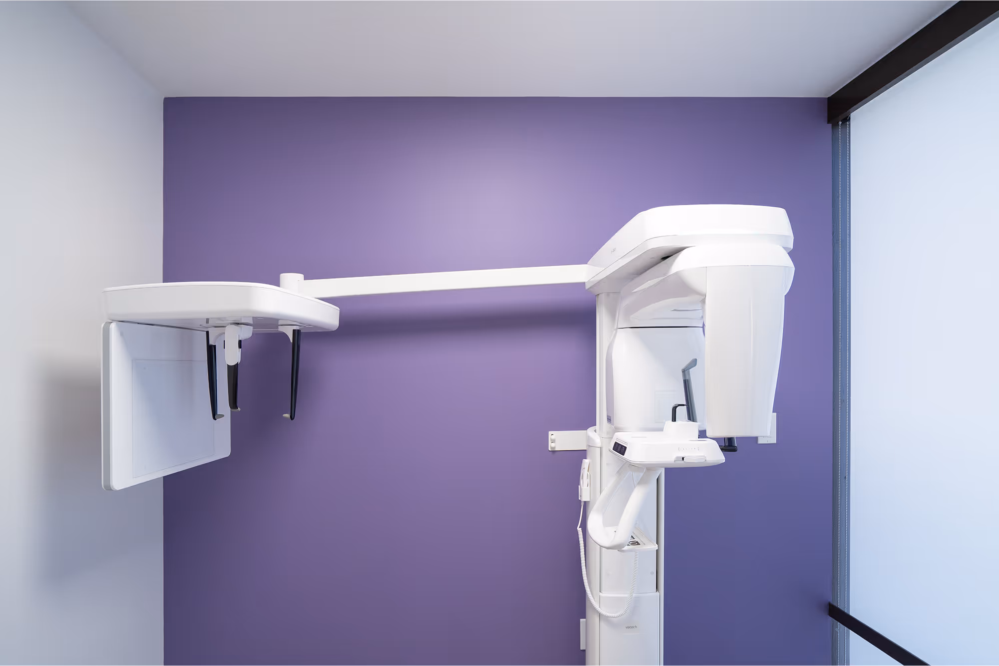 A medical room with a purple wall and a white light.