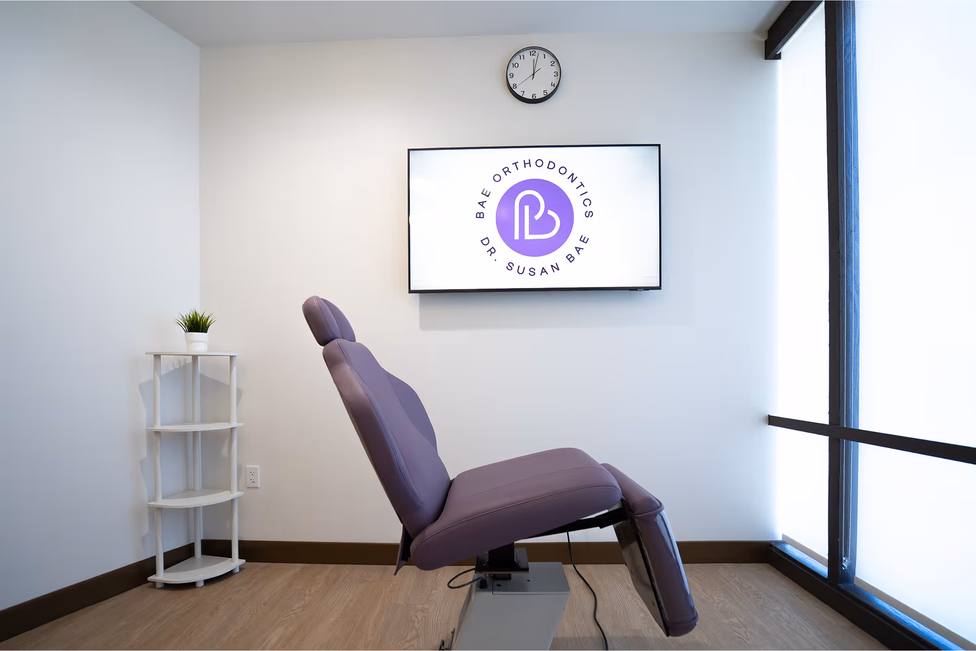 A purple chair sitting in front of a white wall.