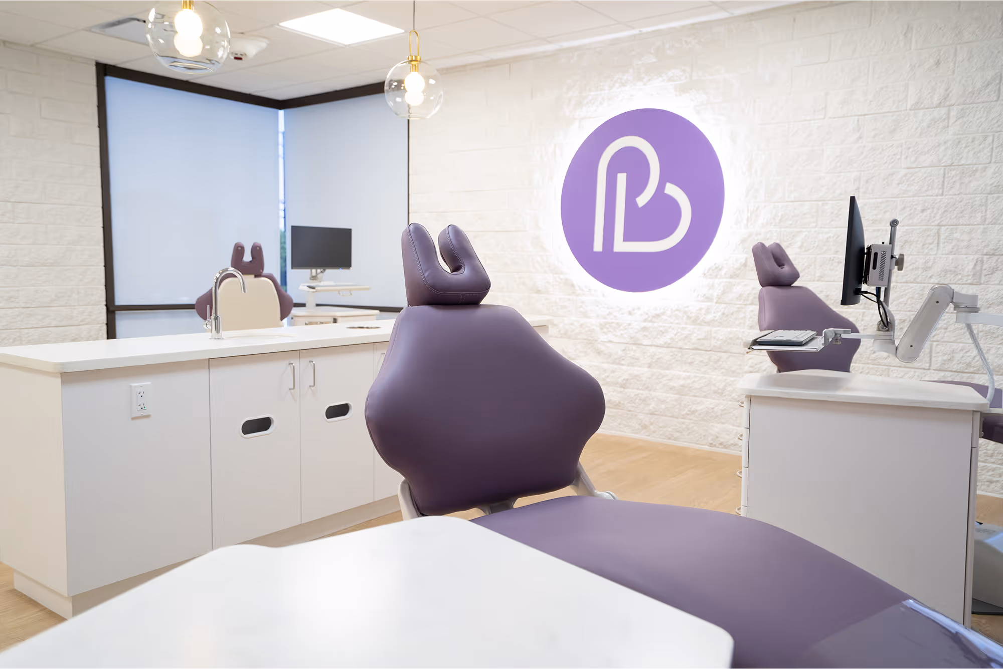 A dental office with purple chairs and a white counter.