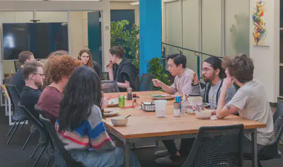 A group gathered round dining tables eating