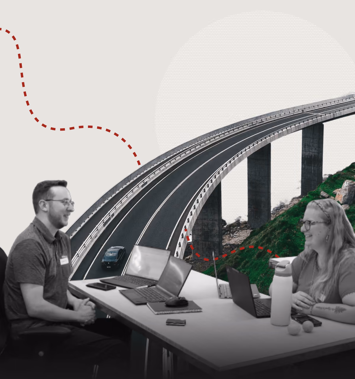 Three professionals sitting at a table with laptops and notebooks, engaged in discussion, with a curved highway bridge and green hill in the background.