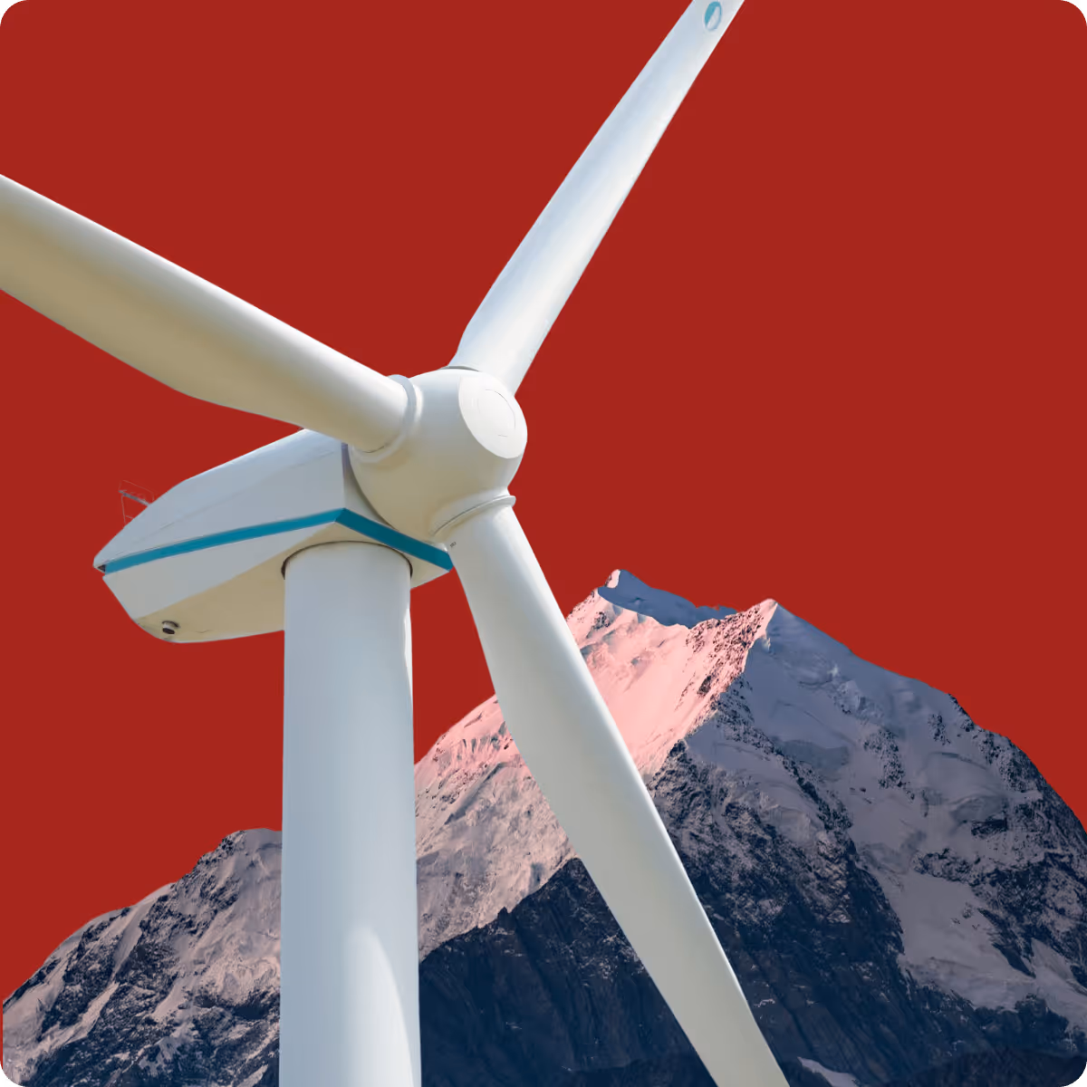 Close-up of a white wind turbine with mountain peaks and a red sky background.