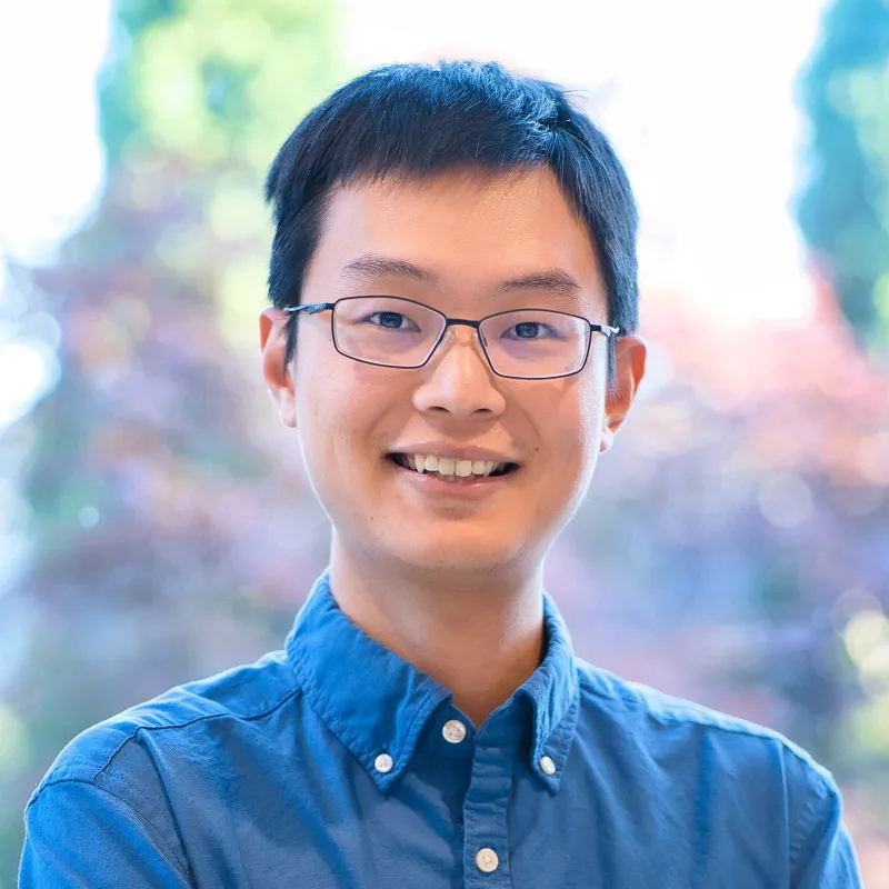A man wearing glasses and a blue shirt.