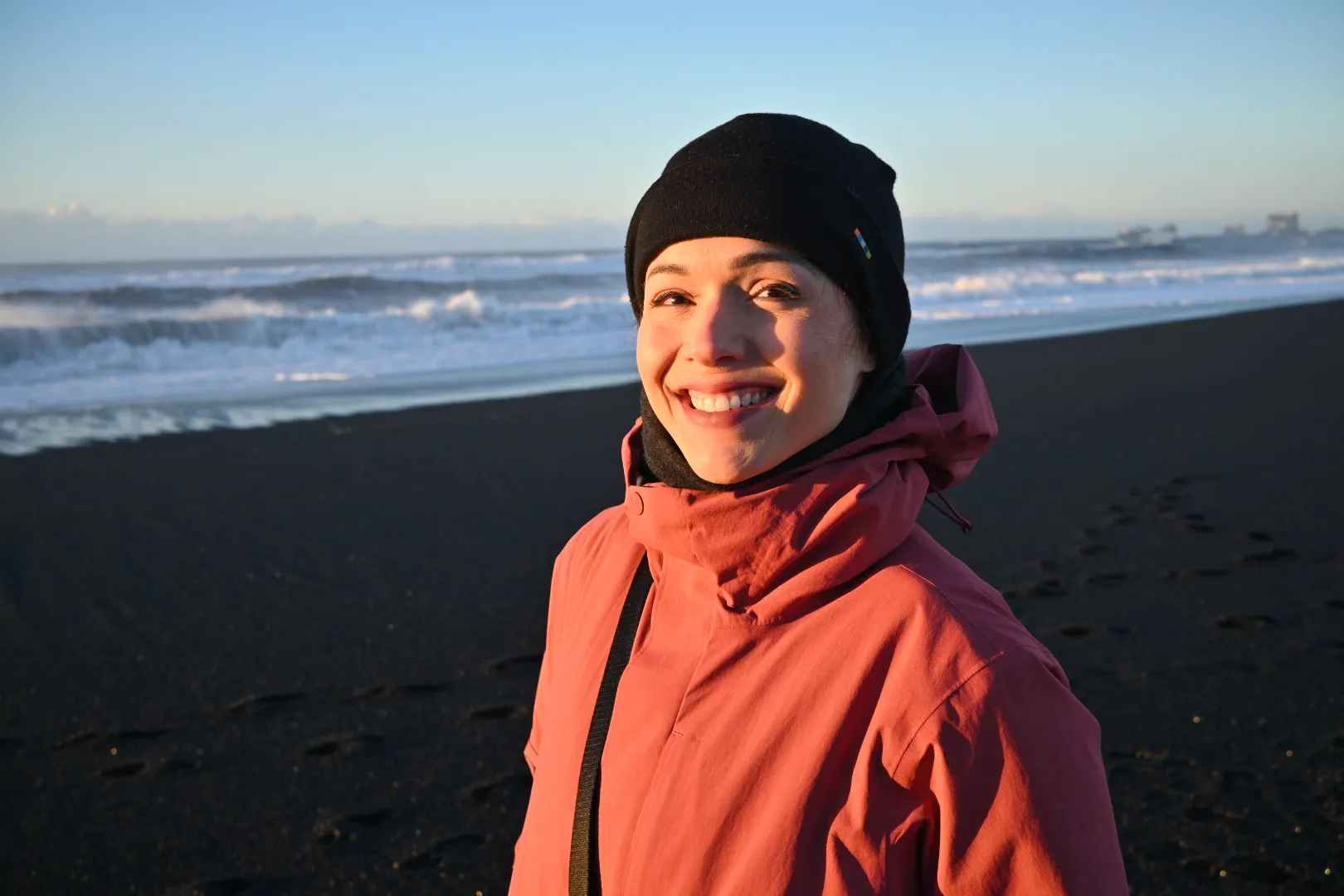 A woman wearing a black hat and a red jacket.