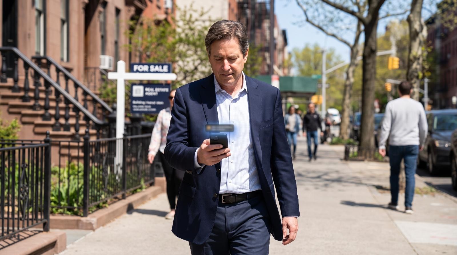 Real estate agent glancing at a phone notification while walking