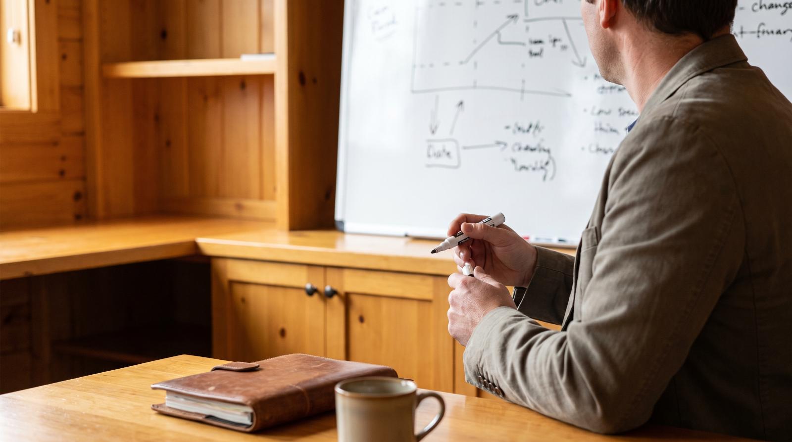 Real estate agent at a whiteboard planning a listing timeline