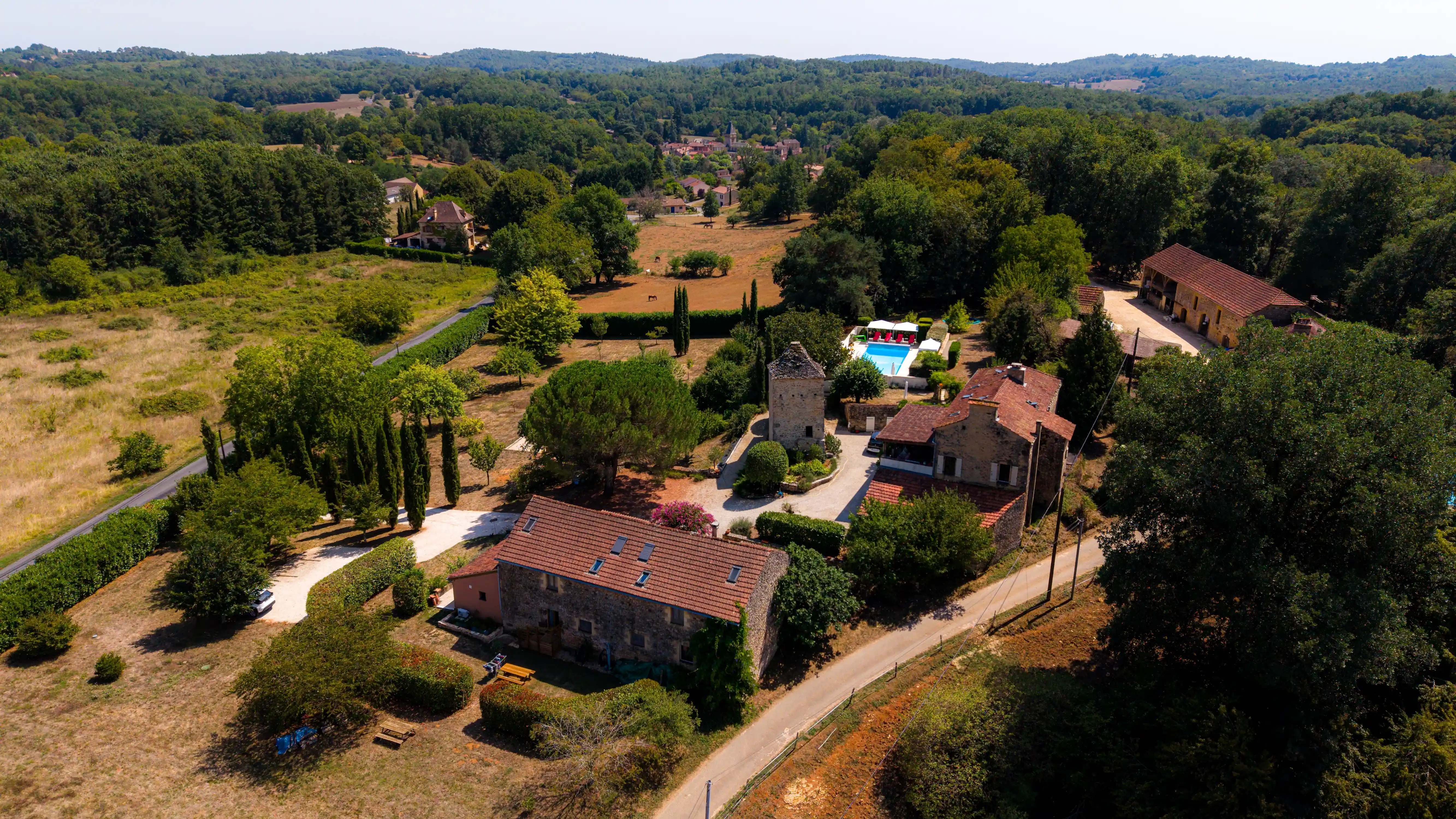 Photo au drone du Domaine du Pigeonnier avec piscine, gîtes, maison principale, parking.