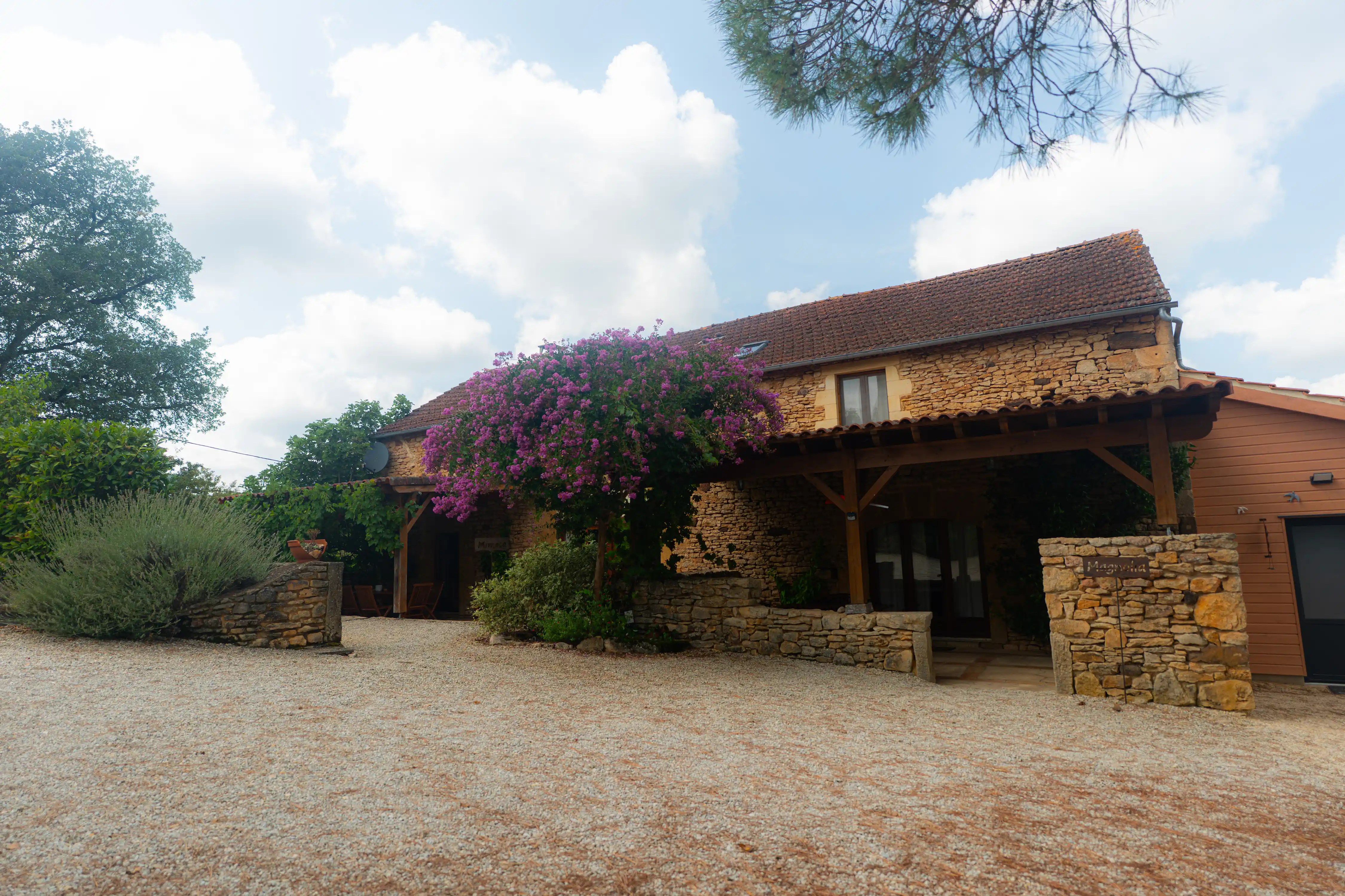 Photo de l'extérieur des gîtes. Bâtiment en pierre. Ancienne grange du Quercy rénovée.