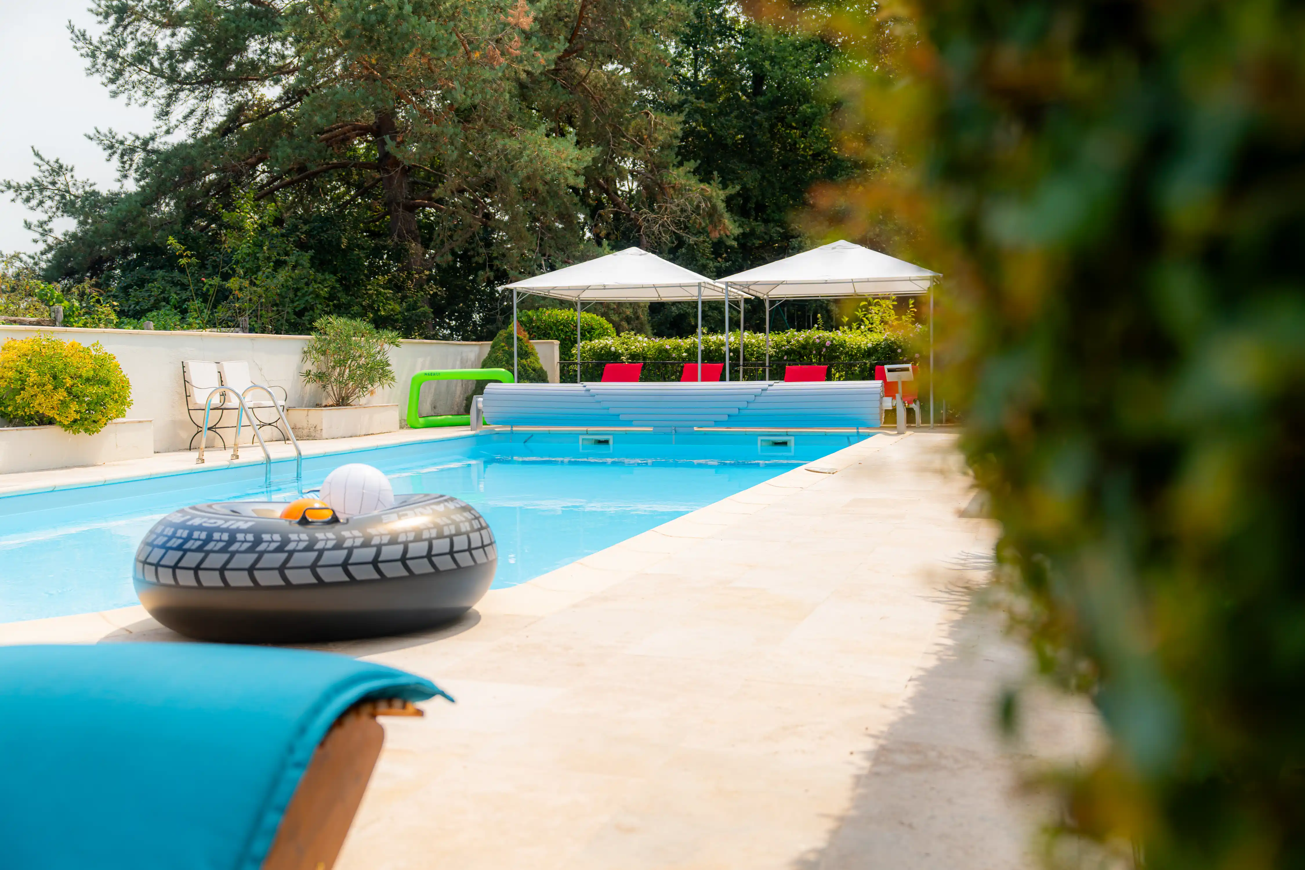 Photo de la piscine, des transats, des bouées et jeux d'eau.