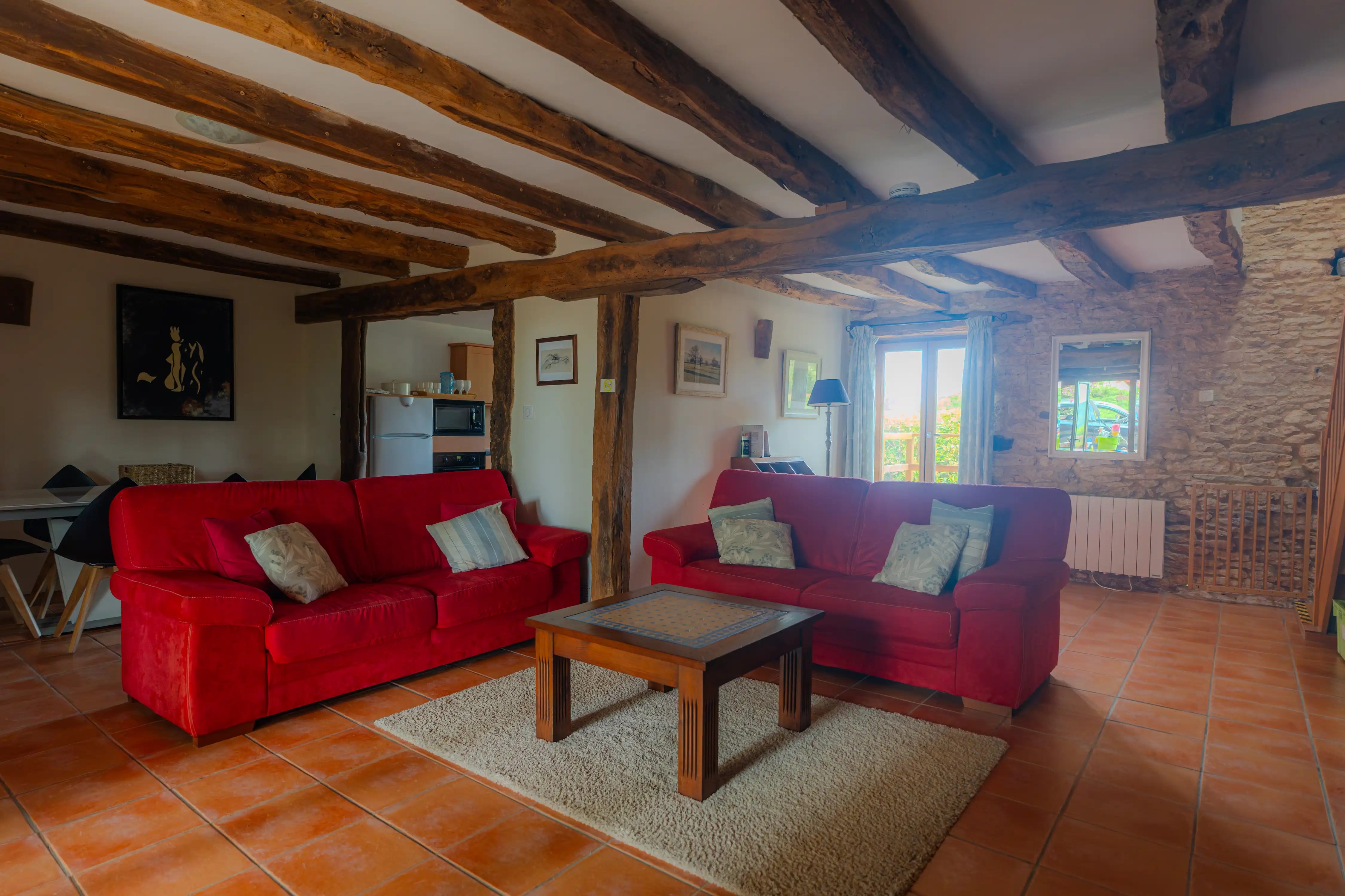 Photo de l'intérieur du gîte Magnolia de 6 places : salon et porte sur le jardin à l'arrière du gîte.