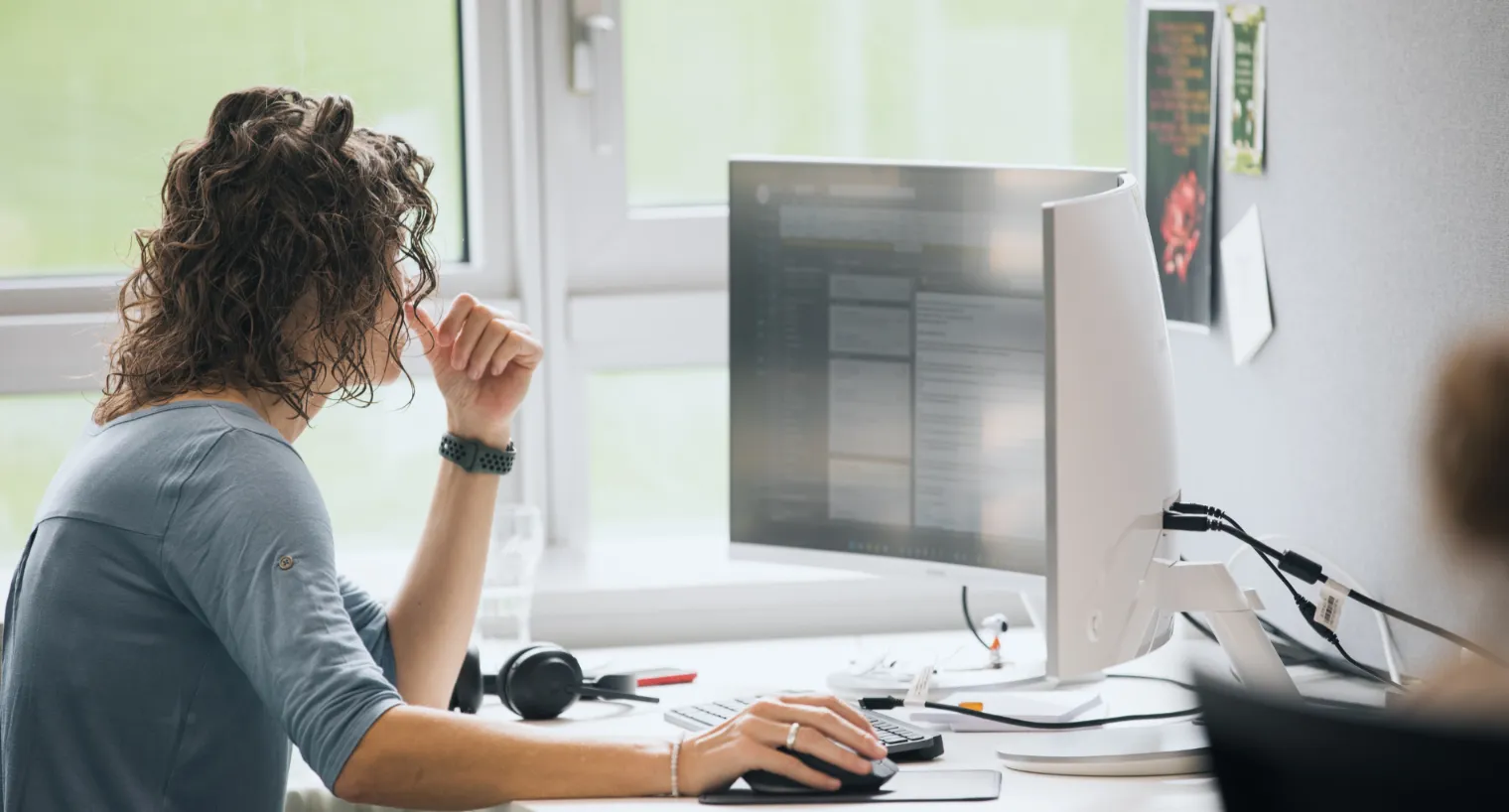 Person arbeitet konzentriert am Computer im modernen Büro