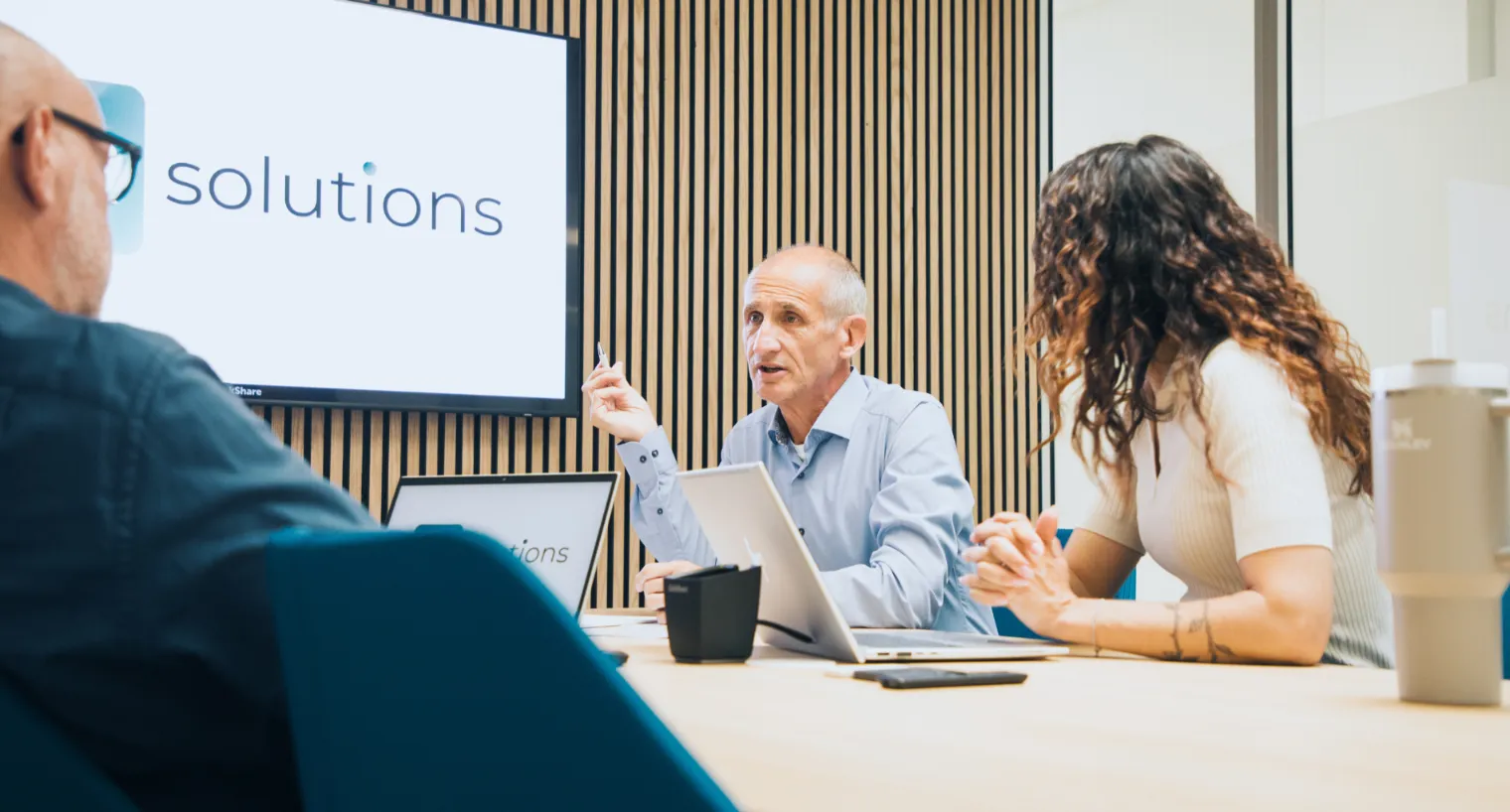 Team bespricht digitale Prozesse in der Treuhandbranche im modernen Meetingraum