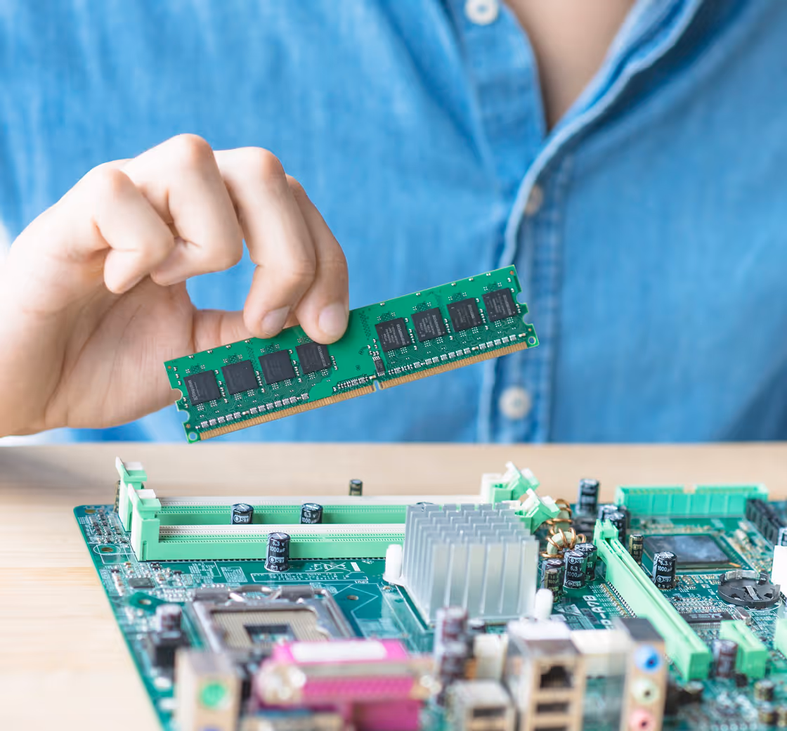 Person installing a RAM memory module into a computer motherboard.