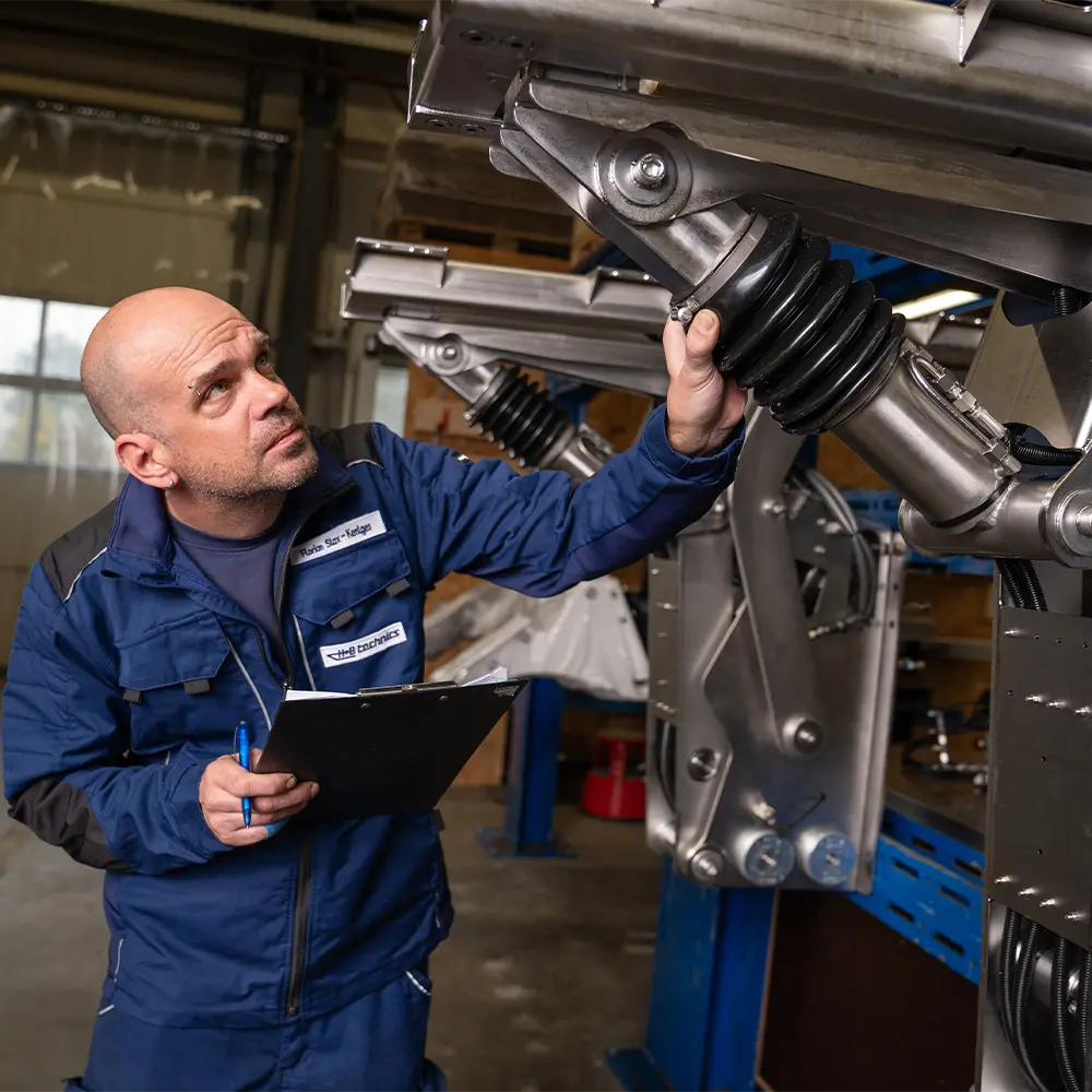 H+B technics engineer performing quality inspection on a hydraulic lift joint assembly