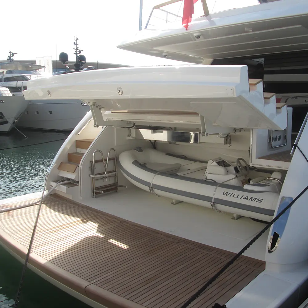 Yacht garage with hydraulic equipment handling system and tender in stowed position