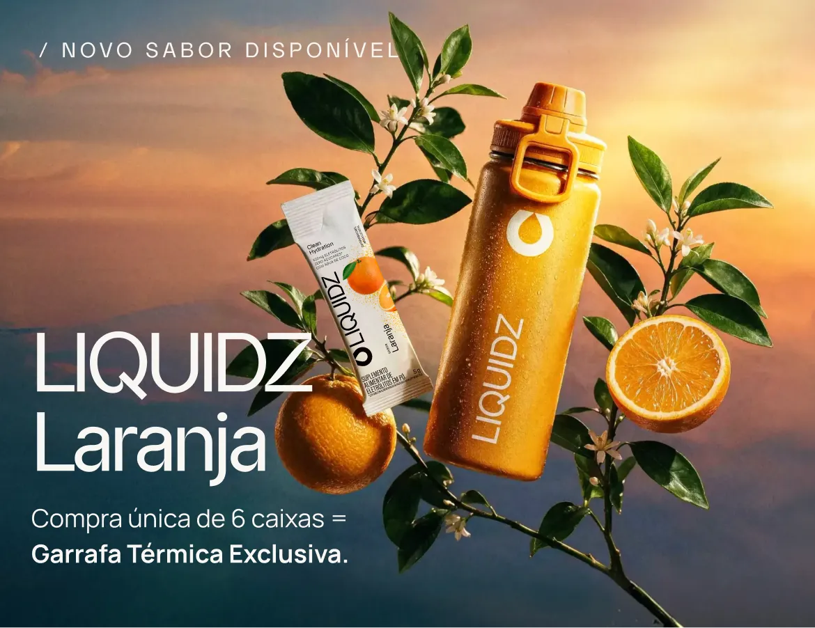 Garrafa e sachê de LIQUIDZ Laranja entre laranjas e flores de laranjeira
