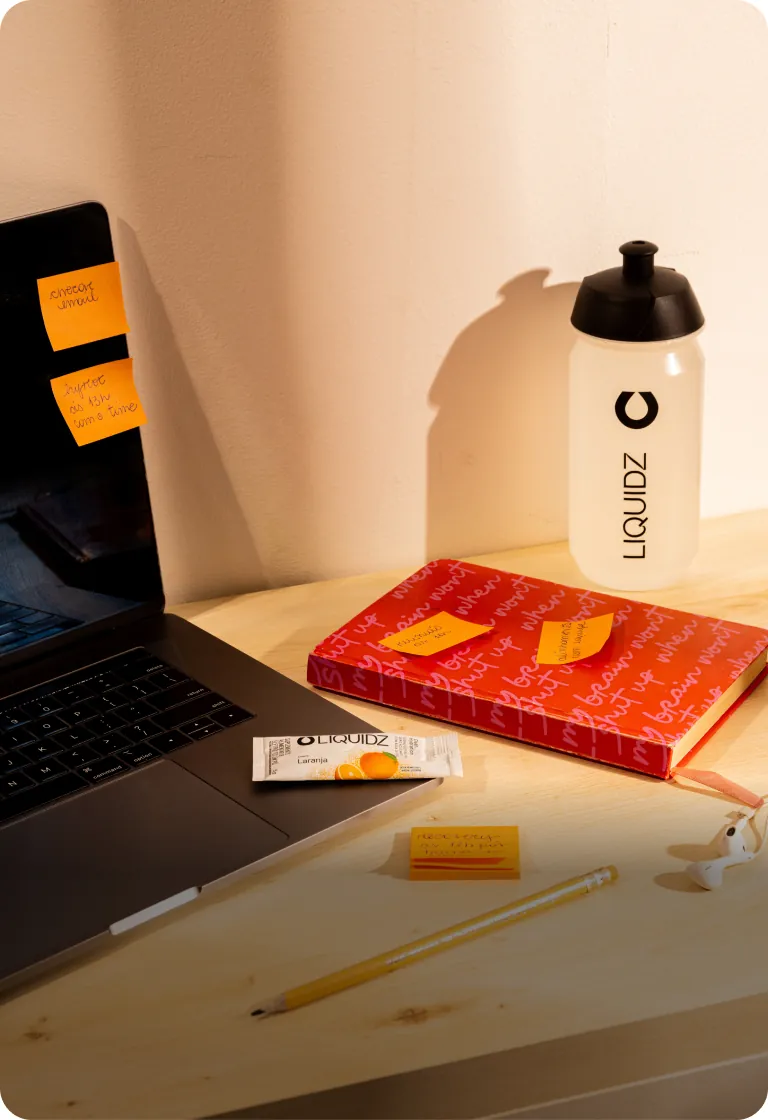 Mesa de trabalho com notebook e garrafa LIQUIDZ