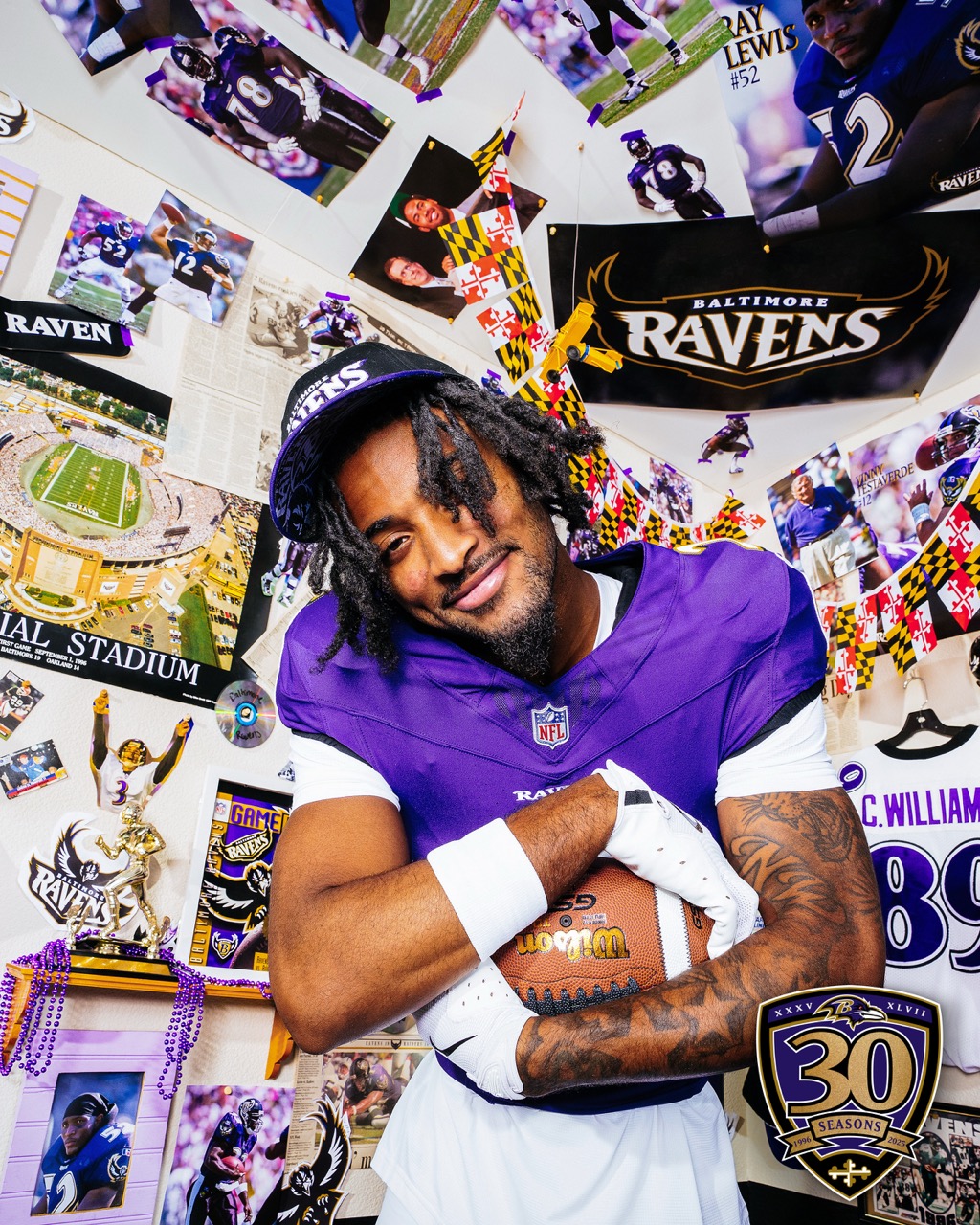 Wigg on the Baltimore Ravens holds a football and strikes a pose in a close up portrait on set