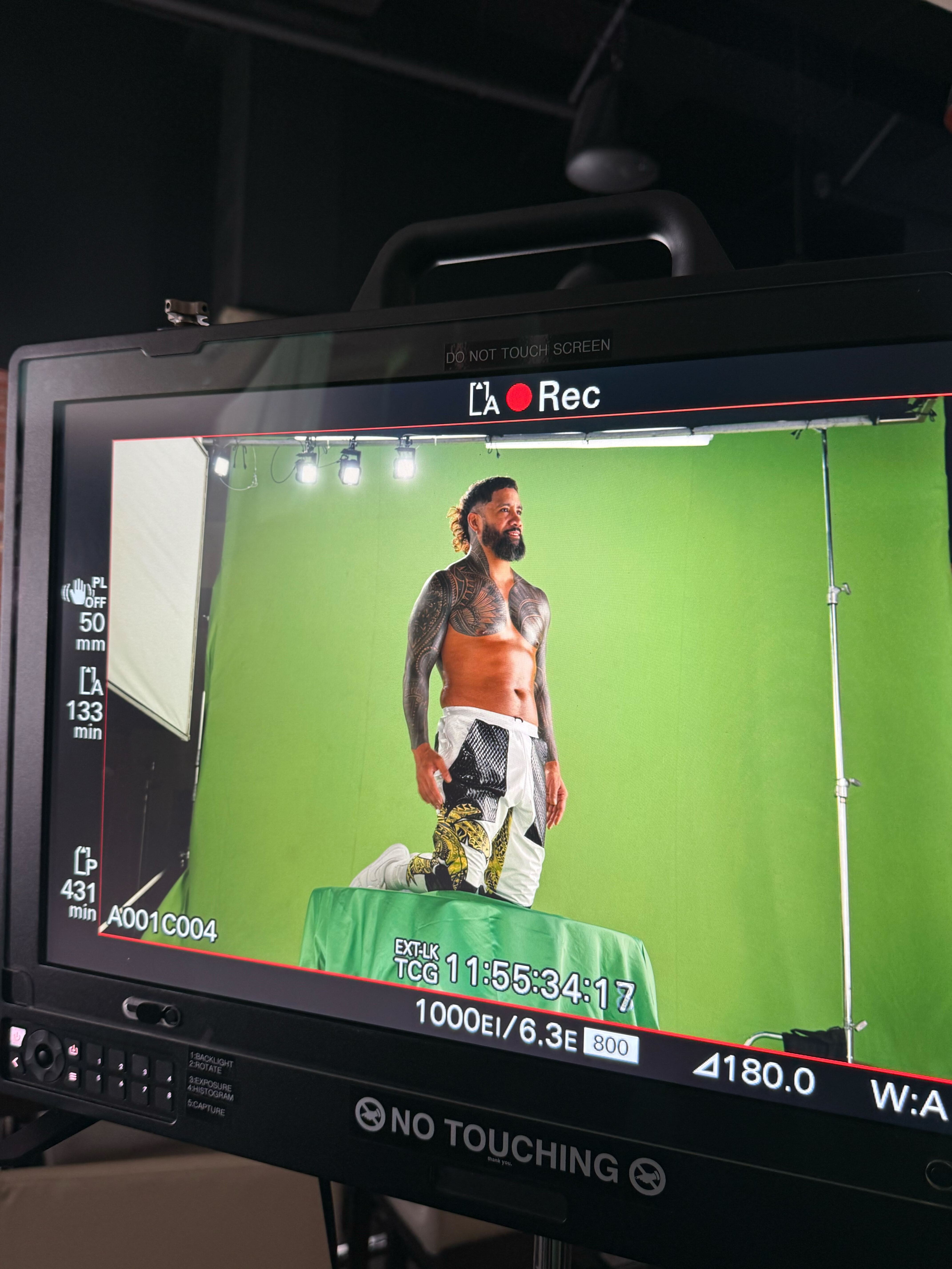 WWE superstar Jey Uso kneels on a greenscreen for the shot thats used in the piece where he is frozen in air