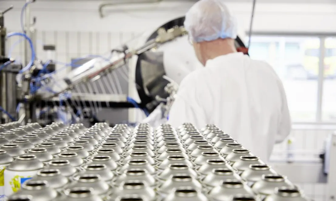 Man, der står foran en masse aerosol dåser på et laboratorie