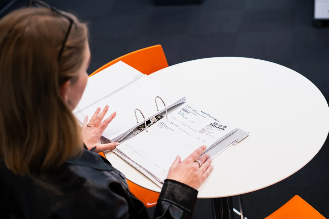 Woman sitting at a desk looking at a binder