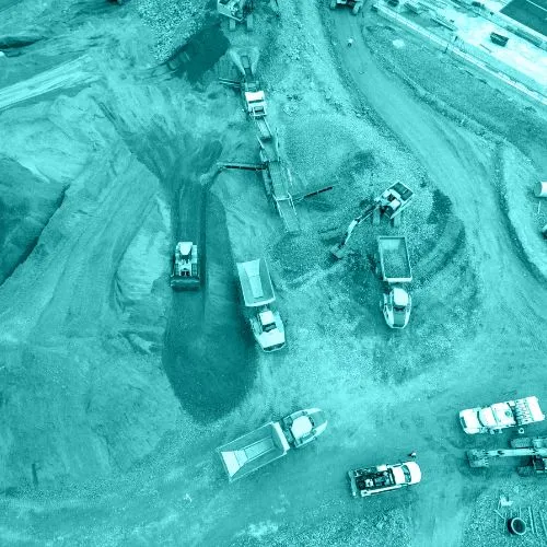 Aerial view of a construction site with multiple trucks and machinery moving dirt and gravel.