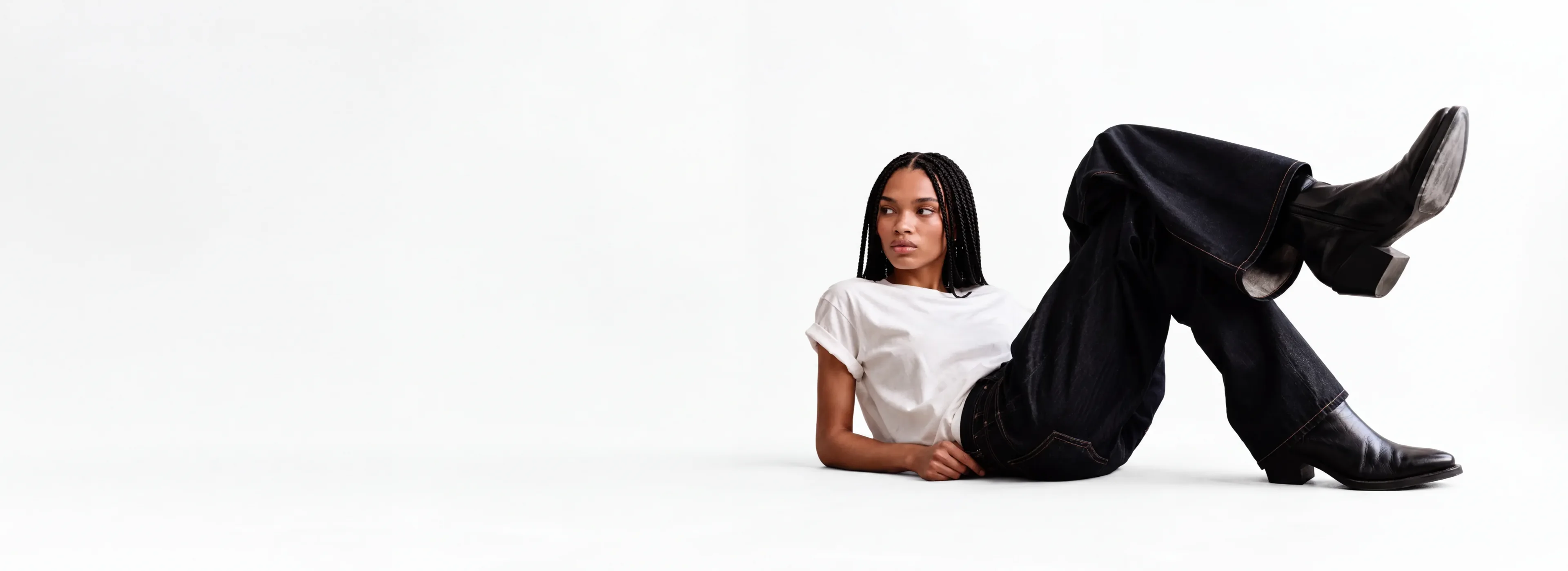 Seated AI generated fashion model on a bright neutral set